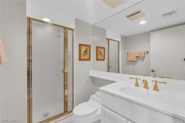 bathroom featuring toilet, vanity, and a shower with shower door