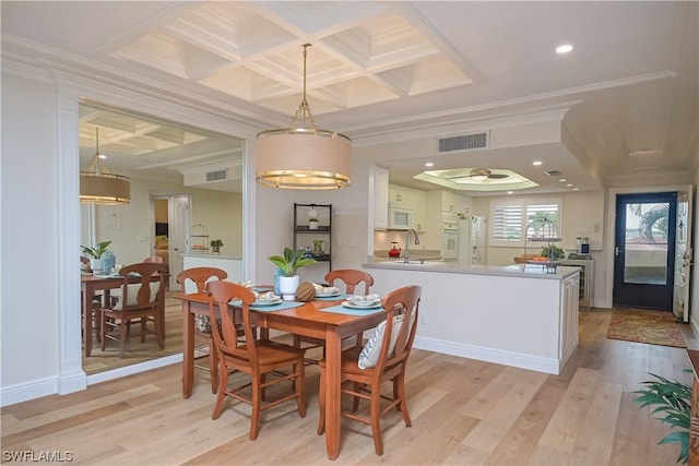 dining room featuring coffered ceiling, sink, crown molding, and light hardwood / wood-style floors