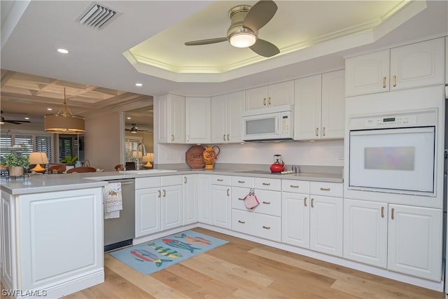 kitchen featuring kitchen peninsula, white appliances, and white cabinets