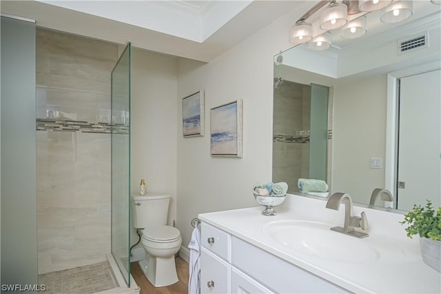 bathroom with a tile shower, vanity, and toilet