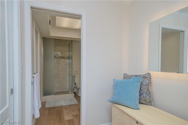 bathroom featuring hardwood / wood-style floors, toilet, and walk in shower