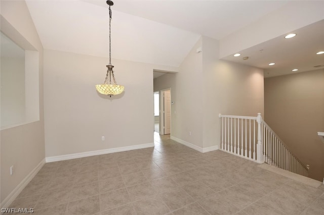 spare room with lofted ceiling and light tile floors