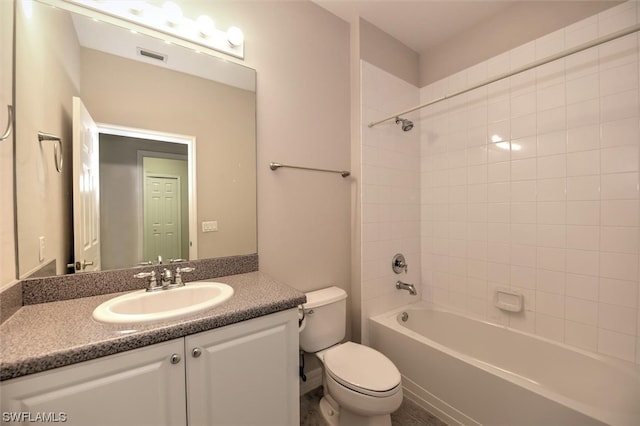 full bathroom featuring oversized vanity, tiled shower / bath combo, and toilet