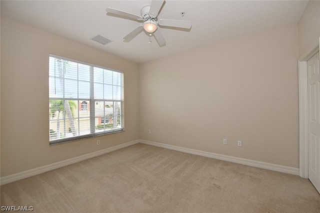 spare room with light colored carpet and ceiling fan