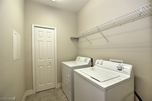 laundry room with washing machine and dryer and light tile floors