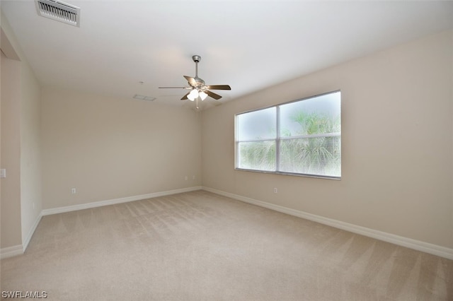 unfurnished room with light colored carpet and ceiling fan