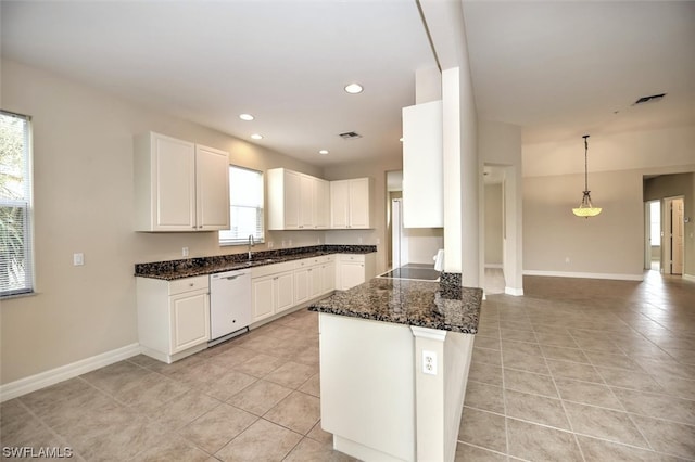 kitchen with pendant lighting, light tile floors, dark stone counters, white cabinets, and white dishwasher