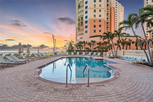 pool at dusk with a patio