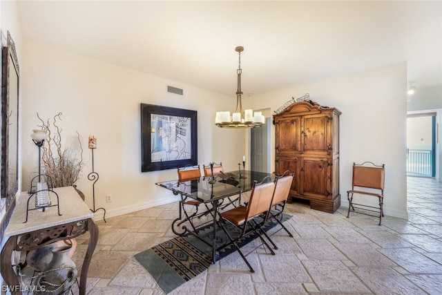 dining room with a chandelier and light tile floors