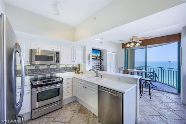 kitchen featuring white cabinetry, kitchen peninsula, appliances with stainless steel finishes, and sink