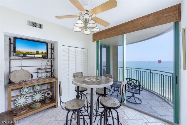 interior space with a water view and ceiling fan