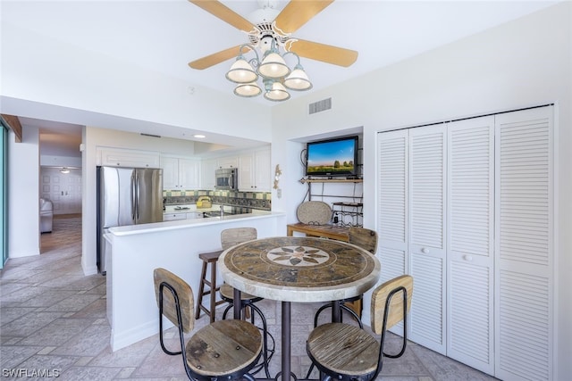 dining space with ceiling fan and light tile floors