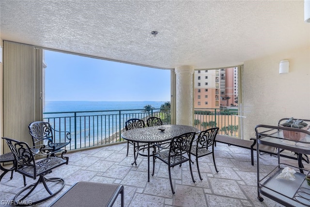 interior space featuring a balcony and a water view