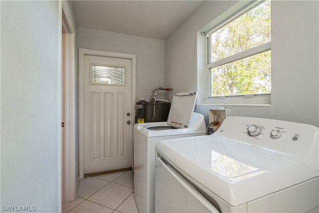 laundry area featuring light tile floors, washer and clothes dryer, electric water heater, and washer hookup