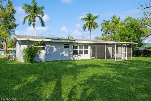 rear view of house with a yard and a sunroom