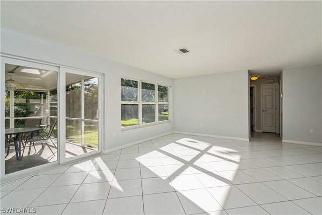 spare room with ceiling fan and light tile floors