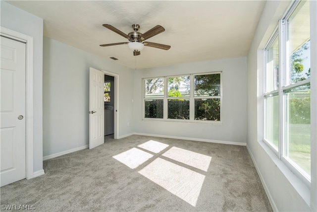 unfurnished bedroom featuring multiple windows, ceiling fan, and light colored carpet