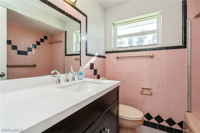 bathroom featuring vanity, tile flooring, toilet, and tile walls