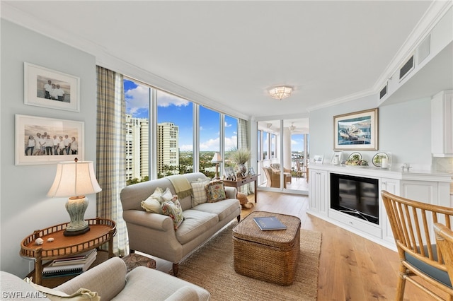 living room with floor to ceiling windows, light hardwood / wood-style flooring, and crown molding