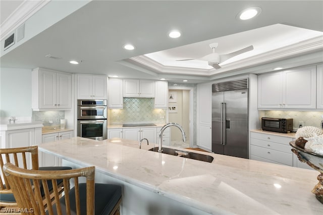 kitchen featuring white cabinets, tasteful backsplash, stainless steel appliances, and sink