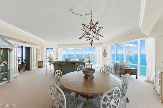 dining room with light colored carpet, crown molding, a healthy amount of sunlight, and a water view