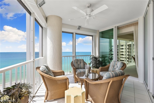 sunroom featuring a water view and ceiling fan