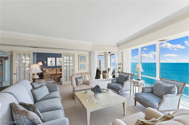 living room featuring light carpet, a water view, french doors, and crown molding