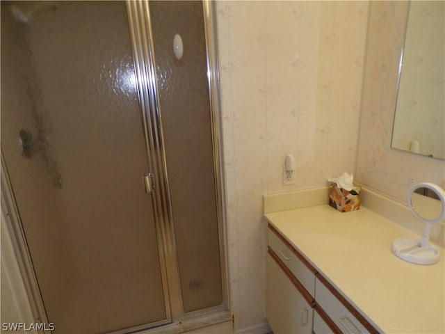 bathroom with vanity with extensive cabinet space and a shower with shower door