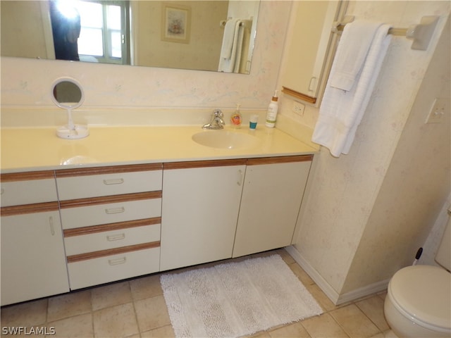 bathroom featuring tile flooring, vanity, and toilet