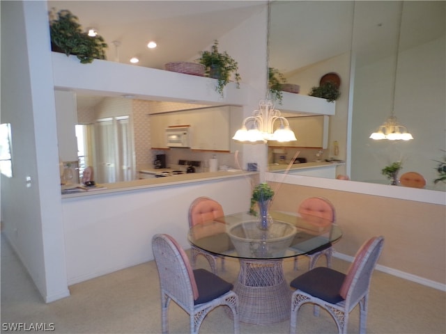 dining space featuring light colored carpet and a notable chandelier