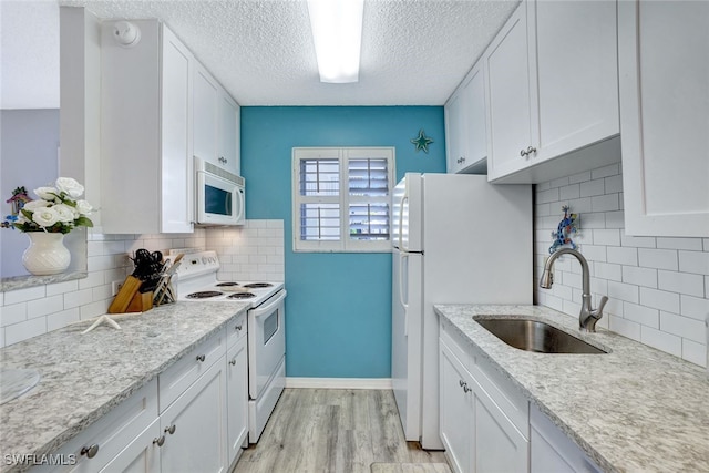 kitchen with sink, backsplash, white cabinets, and white appliances