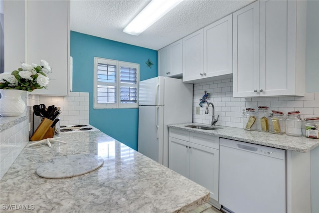 kitchen featuring backsplash, white appliances, a textured ceiling, white cabinets, and sink