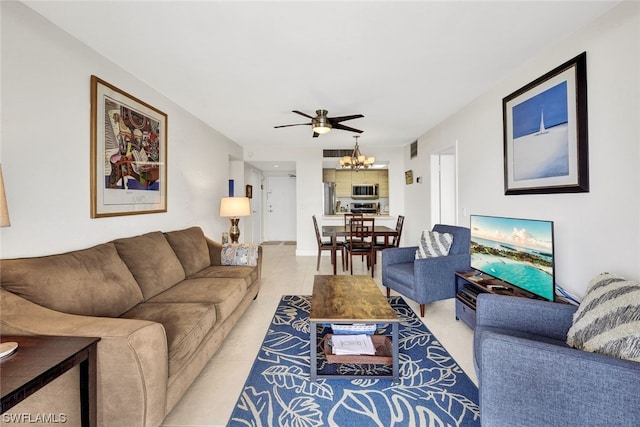 tiled living room featuring ceiling fan with notable chandelier