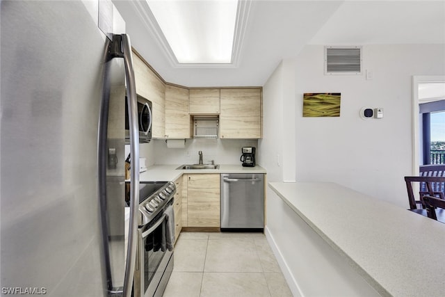 kitchen featuring light brown cabinetry, light tile patterned floors, sink, and appliances with stainless steel finishes