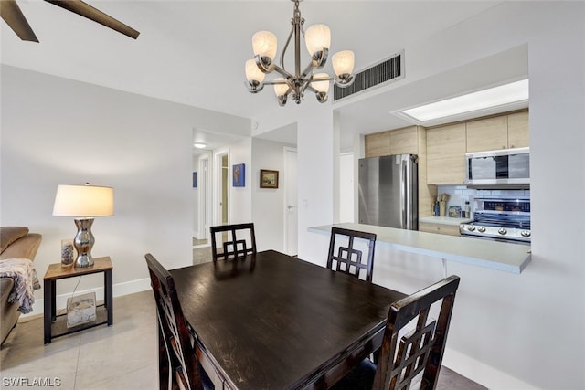 dining area featuring tile floors and ceiling fan with notable chandelier