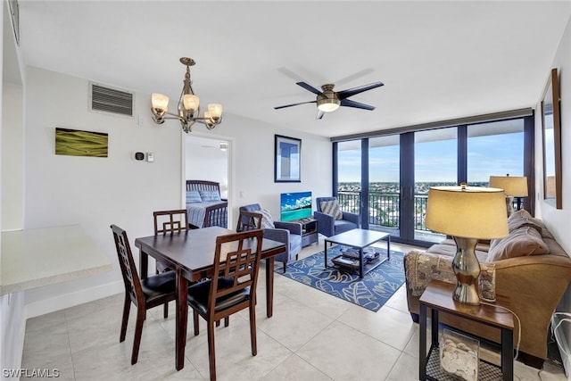 tiled dining area with expansive windows and ceiling fan with notable chandelier