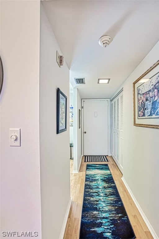 corridor with light hardwood / wood-style flooring