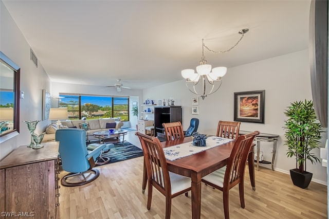 dining area featuring light hardwood / wood-style floors and ceiling fan with notable chandelier