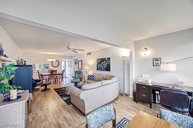 living room featuring ceiling fan with notable chandelier and light wood-type flooring