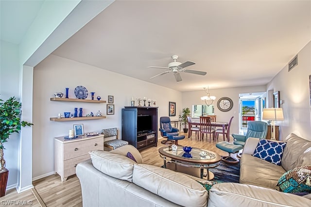 living room with light hardwood / wood-style floors and ceiling fan with notable chandelier