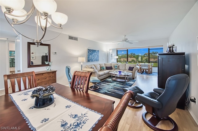 interior space with ceiling fan with notable chandelier and light hardwood / wood-style flooring