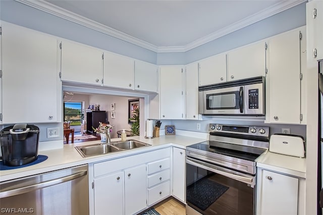 kitchen with sink, crown molding, white cabinets, appliances with stainless steel finishes, and light wood-type flooring