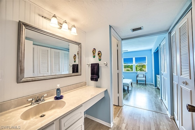 bathroom with hardwood / wood-style floors and oversized vanity