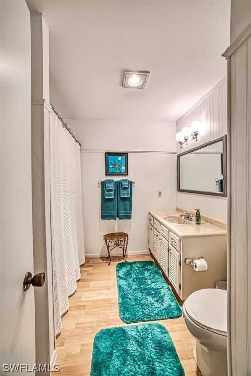 bathroom with toilet, wood-type flooring, and vanity