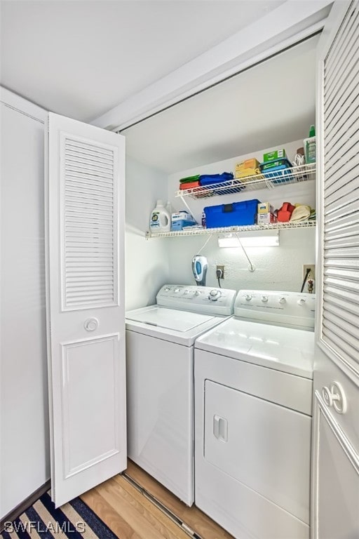 washroom with electric dryer hookup, independent washer and dryer, and light hardwood / wood-style flooring