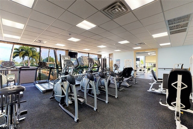 workout area with a drop ceiling and a wealth of natural light