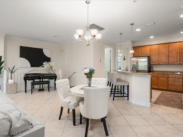 dining area with light tile patterned floors, a notable chandelier, and ornamental molding