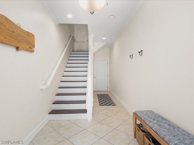 stairway with light tile flooring and crown molding