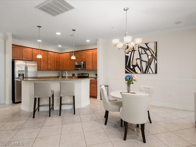 dining area with sink, ornamental molding, a notable chandelier, and light tile flooring