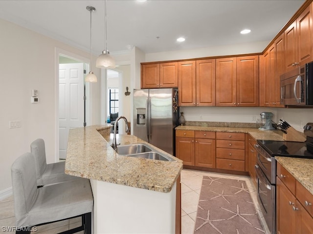 kitchen with decorative light fixtures, appliances with stainless steel finishes, a kitchen island with sink, sink, and light tile floors